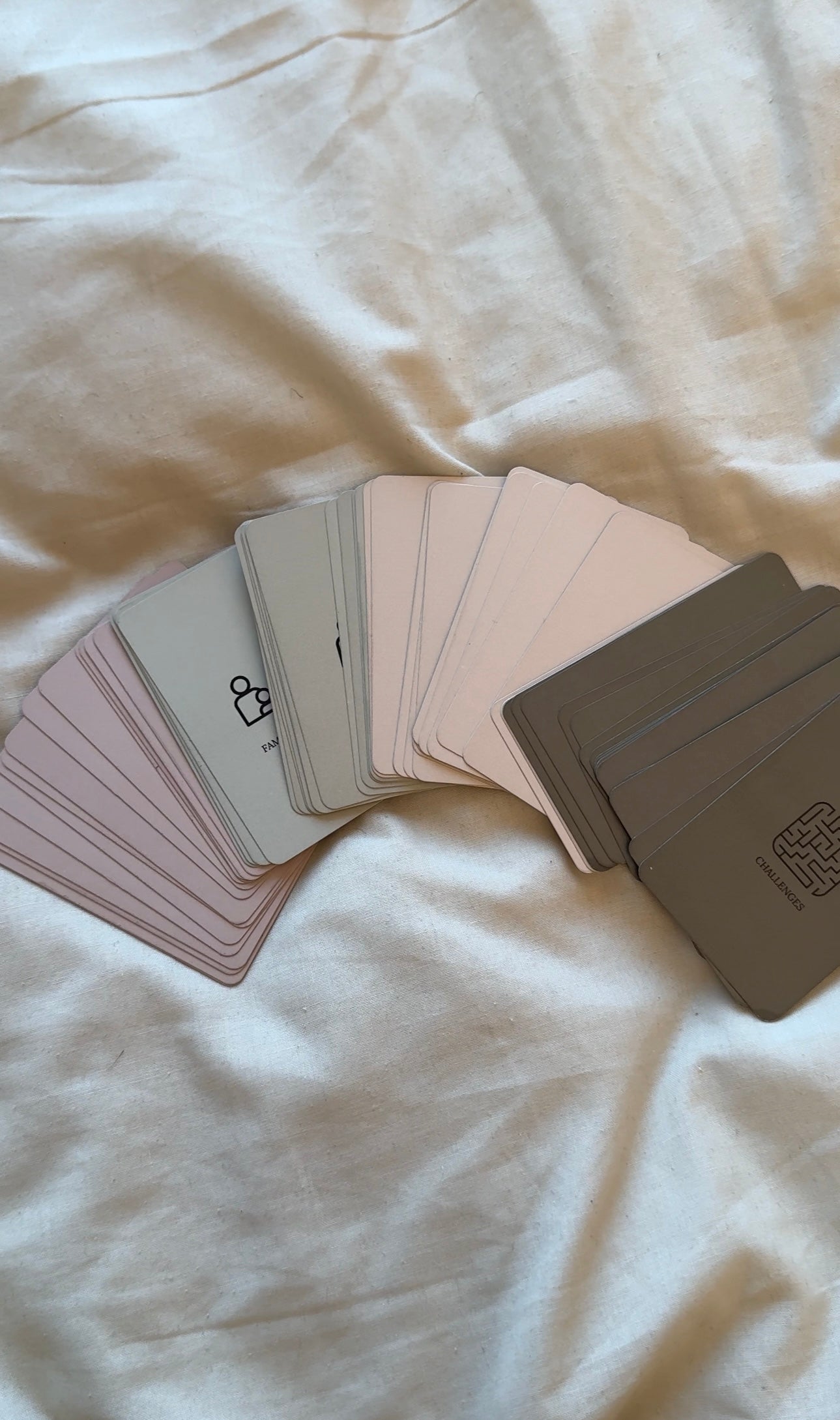 Divine Dialogues card categories fanned out on soft fabric background