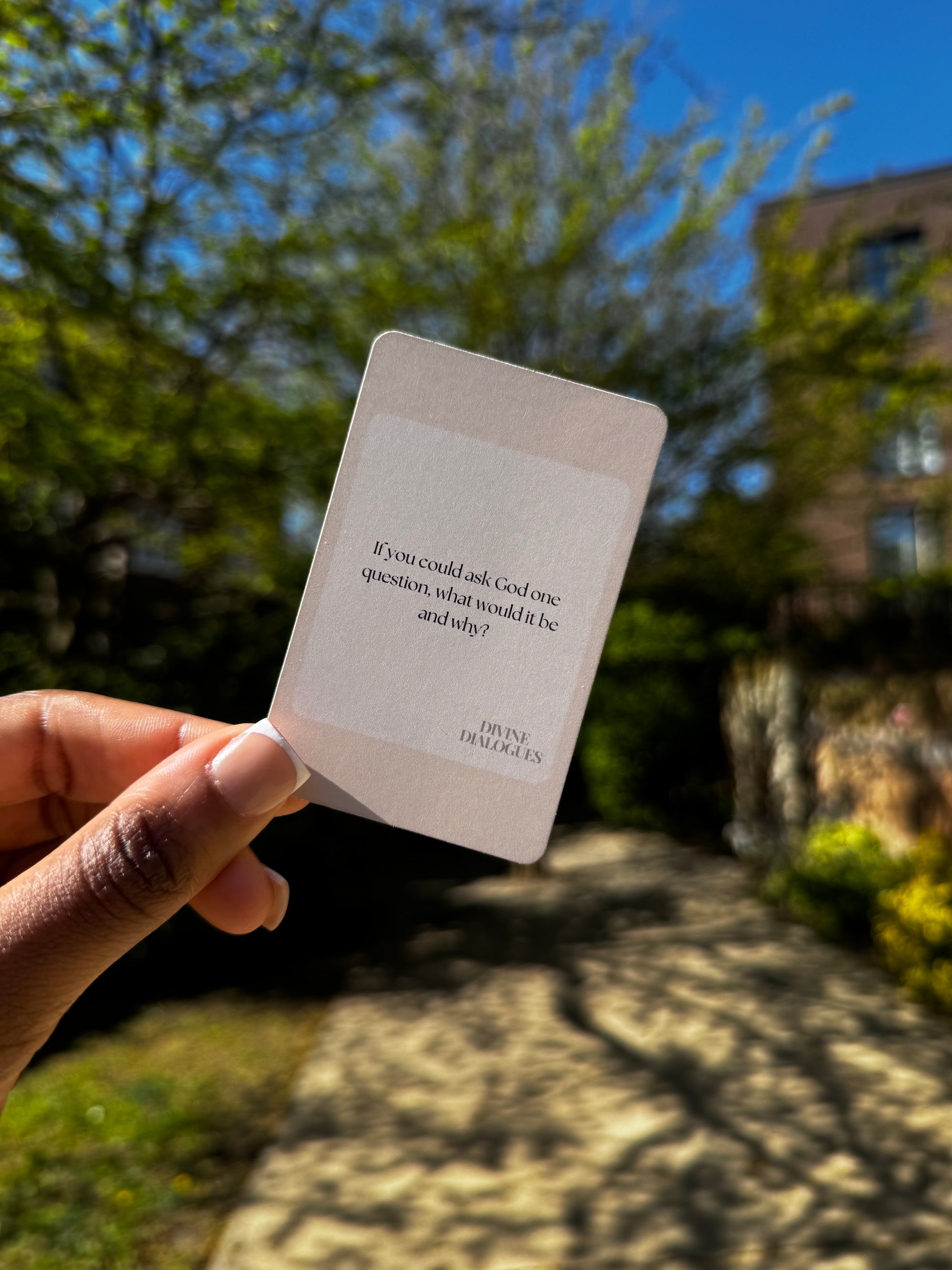 Faith-based question card from Divine Dialogues held outside in natural light